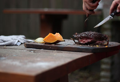 manos cortando carne asada